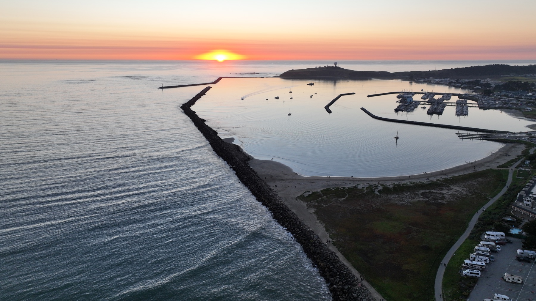 Sunset above Pillar Point Harbor, with the breakwater and marina in the foreground
